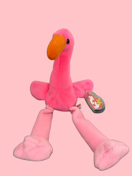 Pink flamingo plush toy with a TY tag on a pink background